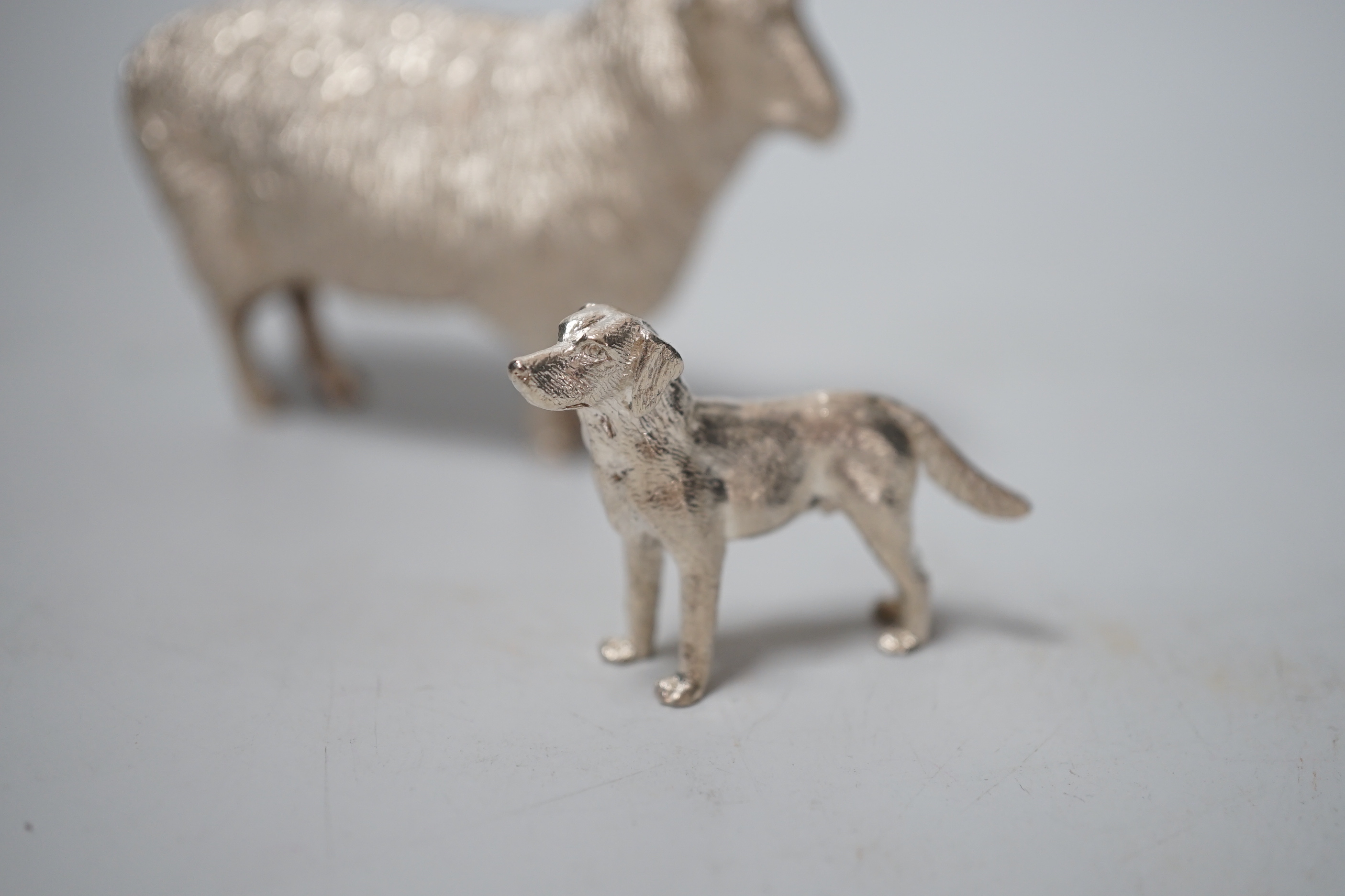 An Elizabeth II silver free-standing model of a sheep, Edward Barnard & Sons Ltd, London, 1993, length 95mm and a smaller silver model free-standing dog, 8.6oz.